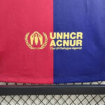 rn-image_picker_lib_temp_e9ff27c3-defd-4f35-a440-1ed8248a000f | UAE SPORT STORE Red and blue fabric with the UNHCR (ACNUR) logo in yellow: emblem with two figures under a laurel, and the text 'UNHCR ACNUR The UN Refugee Agency'