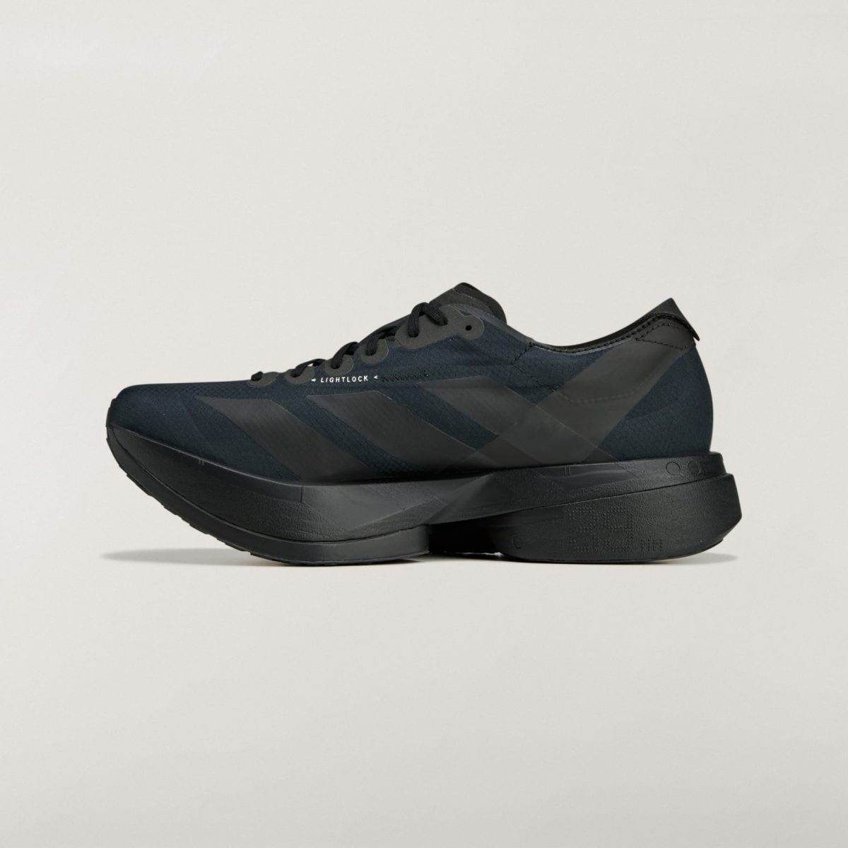 Dark black athletic shoe shown from a low side angle, featuring a thick platform sole and 'LIGHTLOCK' branding on the midsection