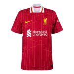 Red Liverpool FC football jersey with yellow crest, Nike swoosh and Standard Chartered sponsor on the chest.