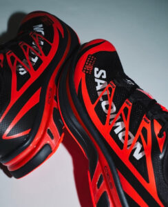 rn-image_picker_lib_temp_f477f1be-9035-46e3-9255-5e78d0562b35 | UAE SPORT STORE Red and black Salomon running shoes with white branding, shown in a close-up angled shot to highlight details and design.