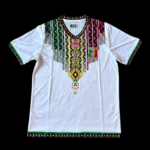 White short-sleeve dashiki with a multicolored geometric pattern around the neckline and fringe tassels; green trim on sleeves and hem.