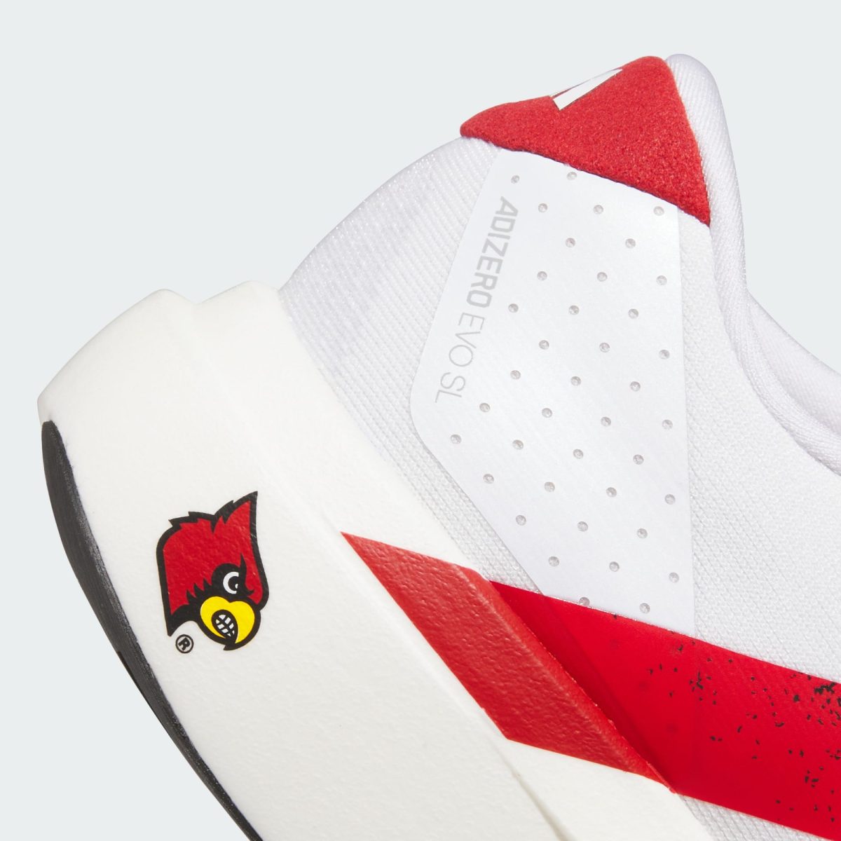 Close-up of a white sneaker with a red accent and perforated panel, showing the Adizero label on the side tag.