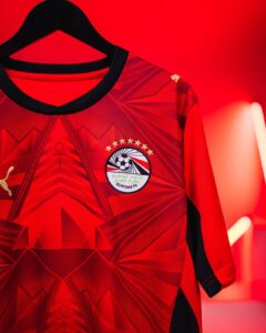 Red football jersey on a black hanger, displaying the Egyptian FA crest with stars on a bold red background.