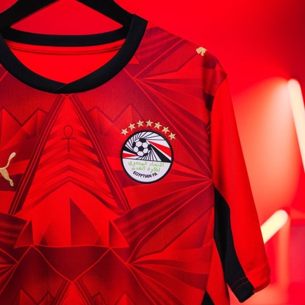 Red football jersey on a black hanger, displaying the Egyptian FA crest with stars on a bold red background.