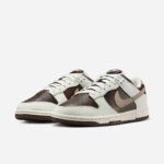 Pair of brown and cream low-top sneakers with white laces placed side by side on a white background.