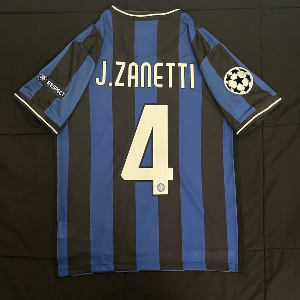 Inter Milan home jersey back view with blue and black vertical stripes, name 'J. Zanetti' and number 4, features UEFA Champions League patch on the right sleeve.
