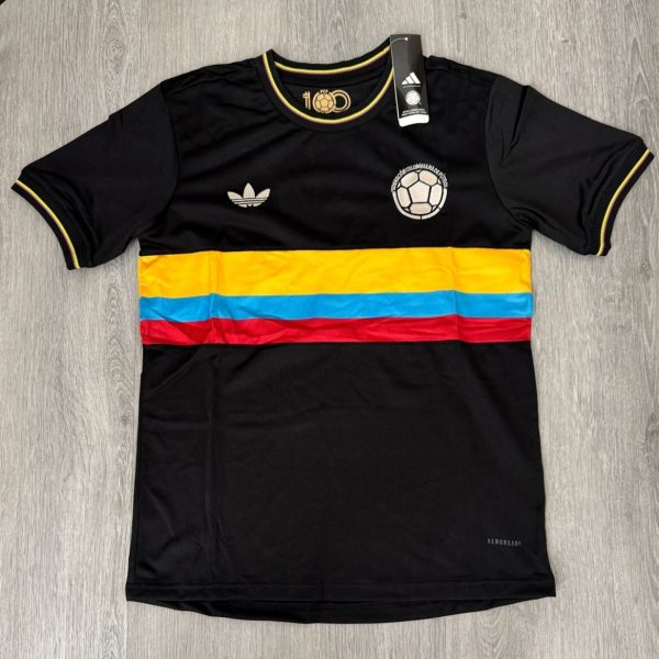 Black Colombia national team jersey with yellow-blue-red horizontal stripe across chest and Adidas logo on the left, size tag attached.