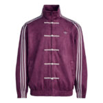 Purple velour Adidas jacket with a stand collar, white toggle fastenings along the front, white side stripes down the sleeves, and front pockets, featuring a small trefoil logo.