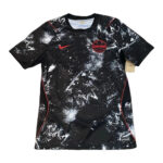 Black Canada national soccer team jersey with red Nike swoosh and white paint-splatter design on the front.