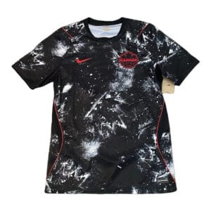 Black Canada soccer jersey with a white splatter pattern, red Nike swoosh, and Canada crest on the chest.