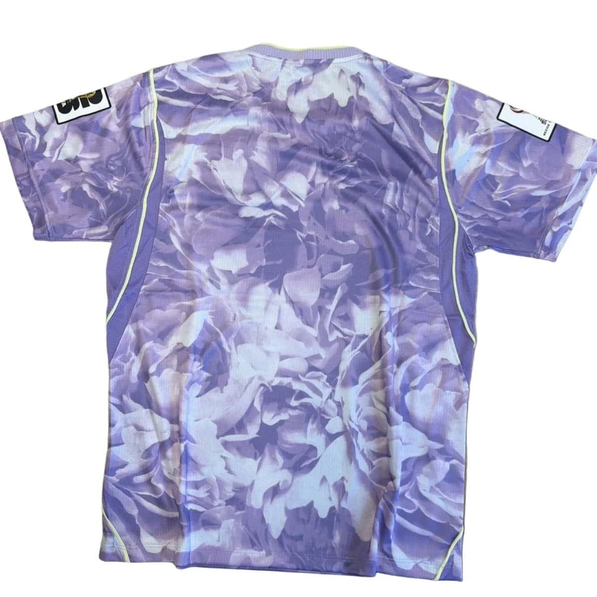 Back view of a purple lavender floral sports jersey with neon lime piping along the side seams and short sleeves.