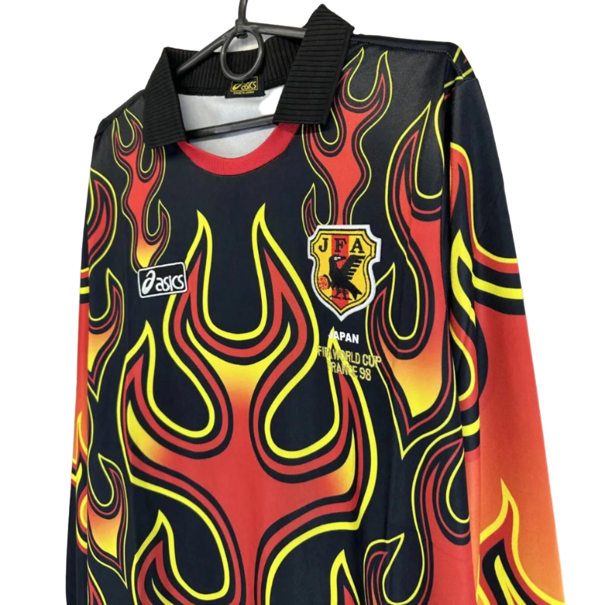 s-l1600_1_b0f1a039-fc8a-4b01-8d77-3a133dae2490 | UAE SPORT STORE Flame-patterned black jersey with red–yellow flames, Asics logo, and JFA crest for Japan 1998 World Cup.