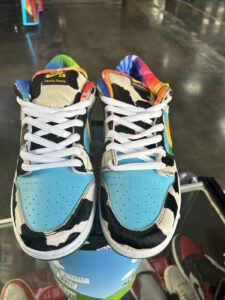 s-l1600_1_dfb674db-4ae0-4e87-a396-207aa3516926 | UAE SPORT STORE Pair of rainbow-colored Nike Dunk Low 'Chunky Dunky' sneakers with cow-print panels and light blue toe caps, white laces, worn on a display shelf