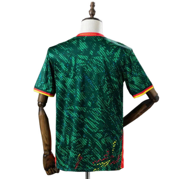 Back view of a green athletic jersey with an abstract lime-green pattern and red/yellow trim on the sleeves, displayed on a dress form.