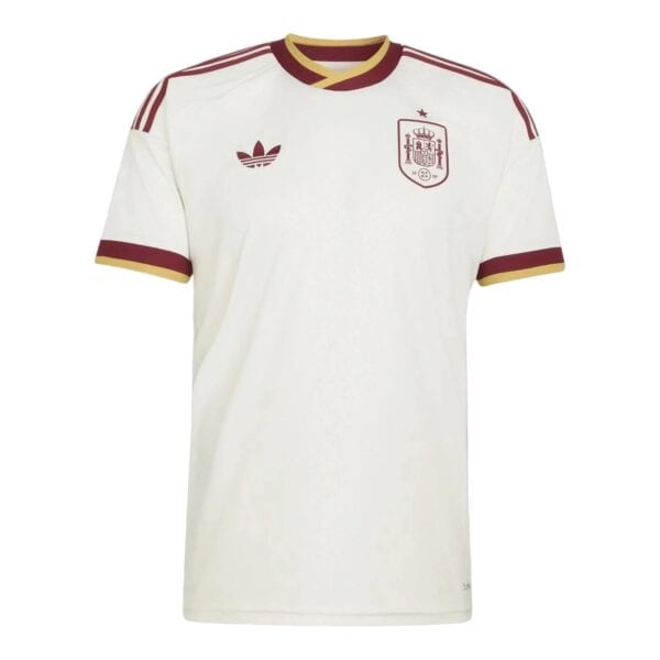 White football jersey with maroon Adidas logo on left chest and Spain crest on right, gold-trimmed collar and sleeve cuffs, maroon stripes on shoulders.