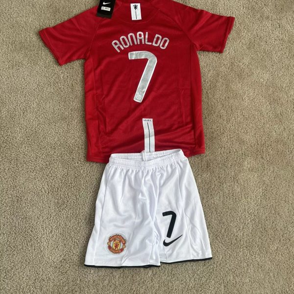 Red Manchester United kid's soccer jersey with 'RONALDO' and number 7 on the back, paired with white shorts displaying the club crest and a large 7.