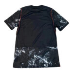 Black short-sleeve T-shirt with white paint-splatter pattern at the hem and sleeve edges, featuring red seam piping on the sides.