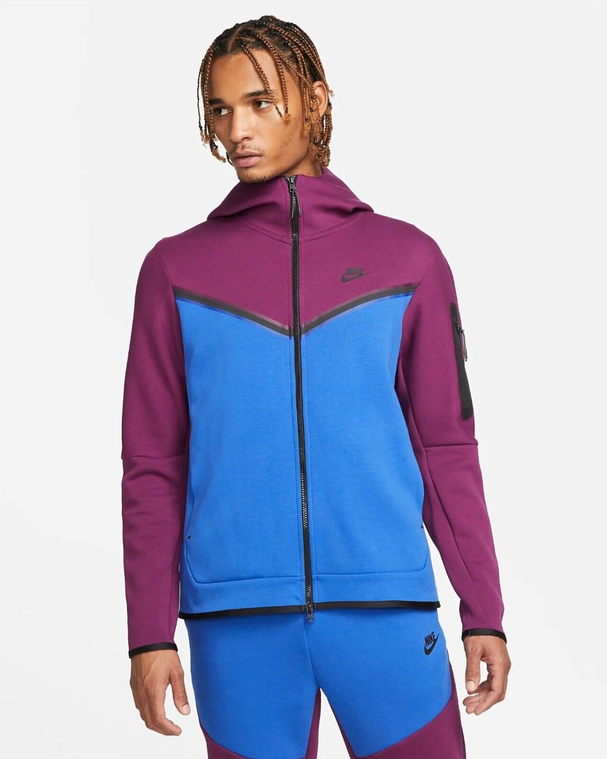 Man modeling a color-block magenta and blue zip-up hoodie/jacket with a high collar and visible Nike logo on the chest image.
