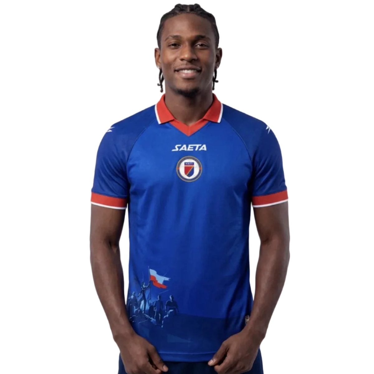 Portrait of a man in a blue Haiti national team soccer jersey with red collar, standing against a white background.