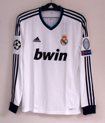 Real Madrid white football jersey with black Adidas stripes, bwin sponsor, crest, and Champions League badge on the sleeve.
