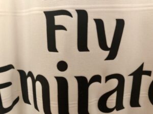 Close-up of the Fly Emirates branding on a white surface.
