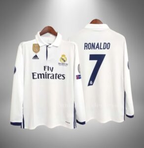 White Real Madrid jersey on hangers, front shows Fly Emirates sponsor and club crest with patches on sleeves and collar detail.
