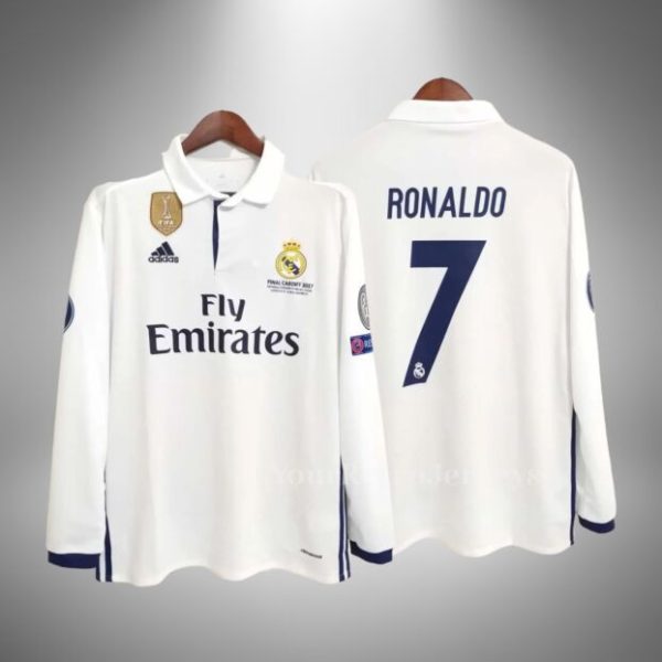 White Real Madrid jersey on hangers, front shows Fly Emirates sponsor and club crest with patches on sleeves and collar detail.