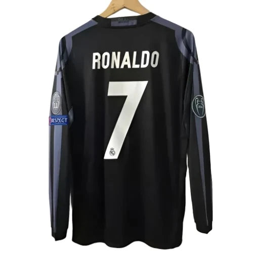 Black Real Madrid football jersey with Ronaldo number 7 on back, hanging on a wooden hanger.]','Back view of a Real Madrid long-sleeve jersey reading RONALDO and 7, with league patches on sleeves.','Ronaldo 7 Real Madrid jersey displayed on a hanger.