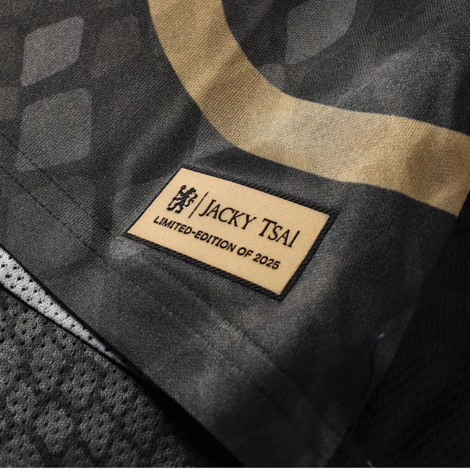 s-l960_15 | UAE SPORT STORE Close-up of a beige fabric tag sewn into a dark camo jacket that reads ‘JACKY TSAI’ and ‘LIMITED-EDITION OF 2025’.