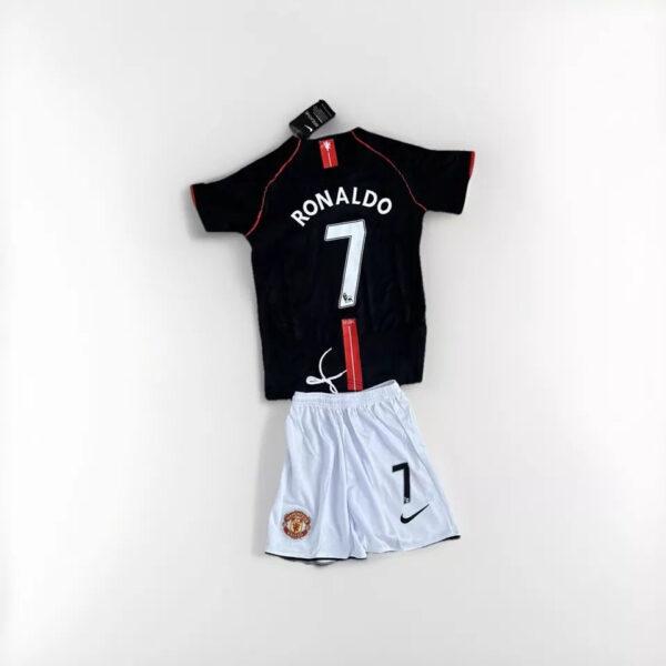 Black Ronaldo 7 football jersey with red piping paired with white Manchester United shorts featuring the number 7 and Nike logo, laid flat.