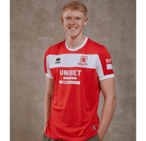Portrait of a young man in a red and white football jersey with Unibet sponsor, standing against a neutral backdrop.