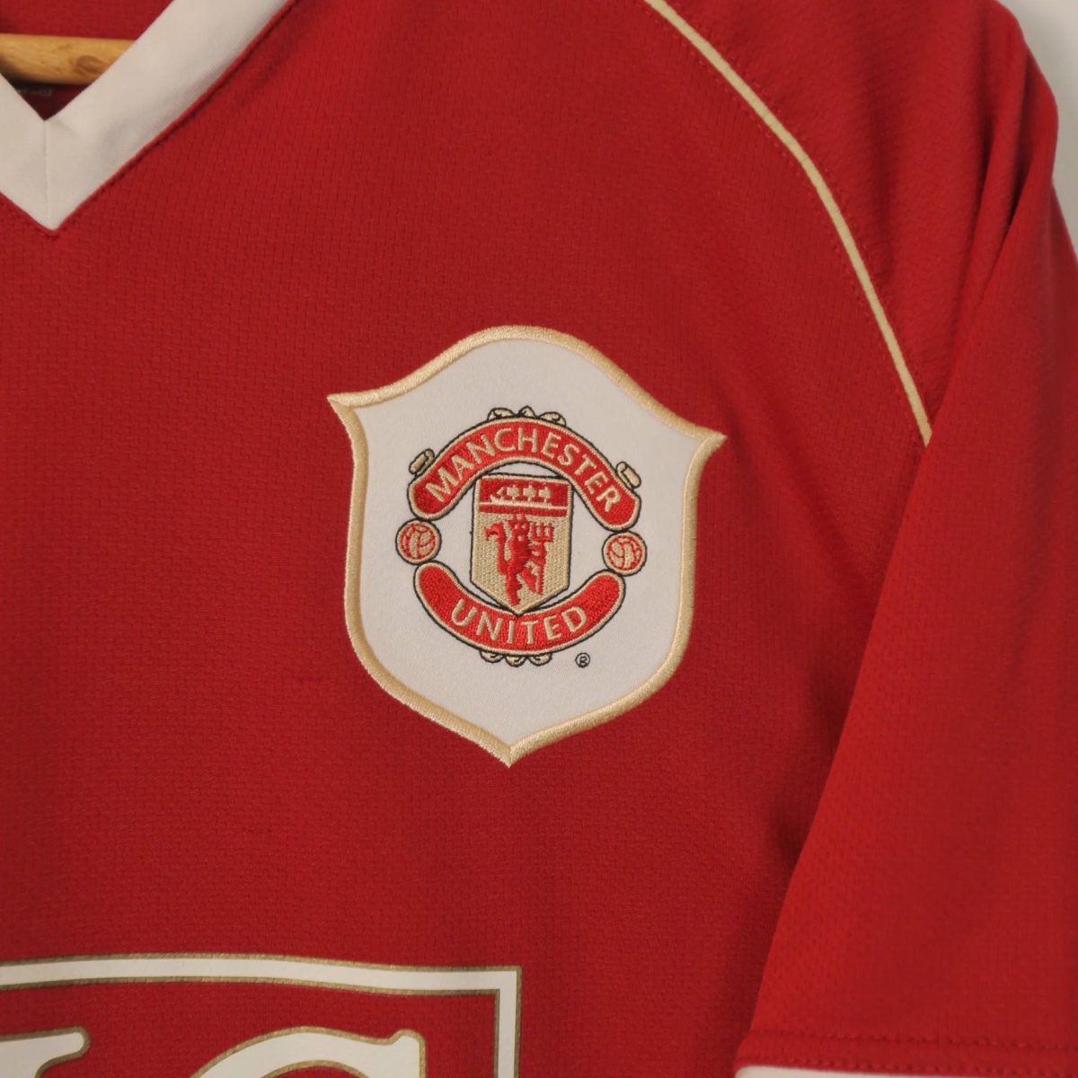 Close-up of a red Manchester United jersey with the club crest on the chest.