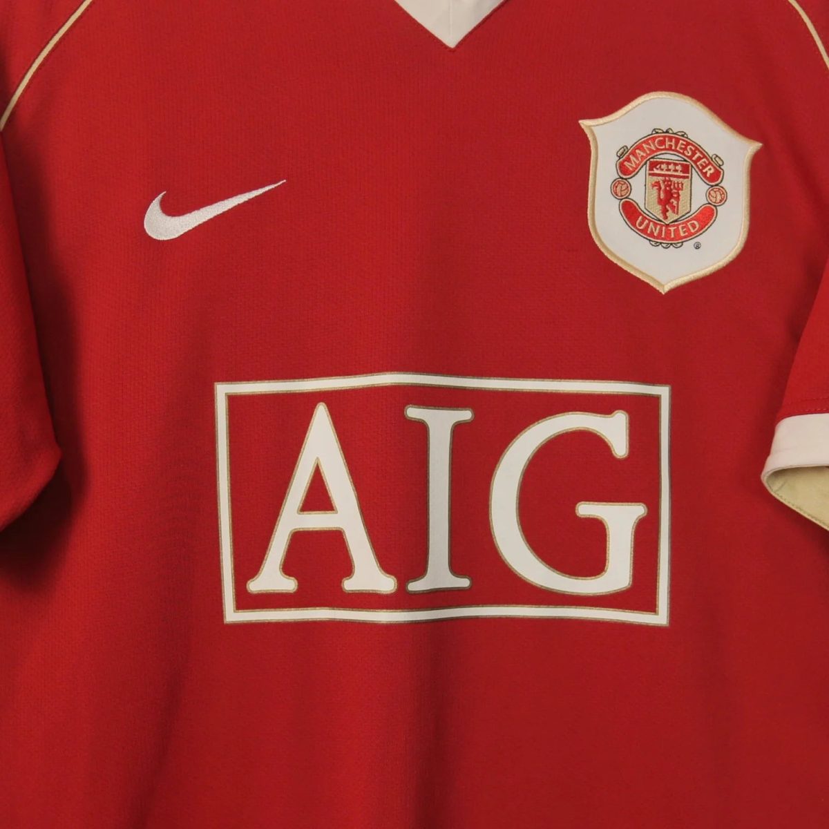 Red Manchester United jersey front: visible white Nike swoosh and club crest over sponsor area.