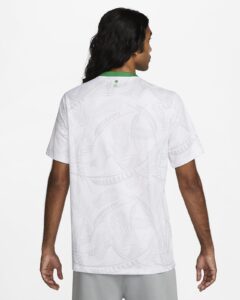 Back view of a white short-sleeve shirt with a tropical palm leaf pattern and a green collar trim