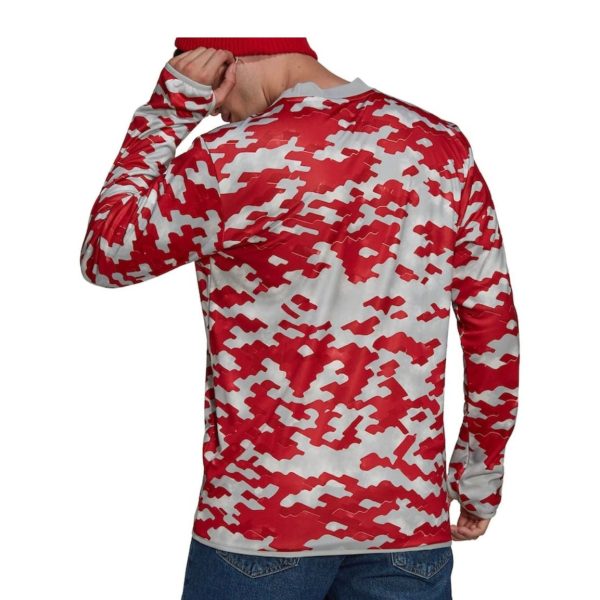 Back view of a person wearing a red-and-white camo long-sleeve shirt and blue jeans, with a red hat partially visible at the top edge.