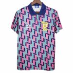 Geometric pink, teal, and navy football jersey with a blue collar, Umbro logo, and the Scotland Football Association crest on the chest.