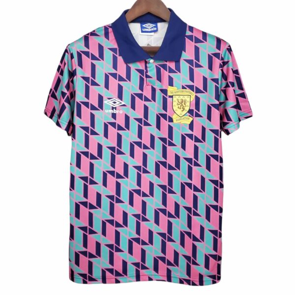 Geometric pink, teal, and navy football jersey with a blue collar, Umbro logo, and the Scotland Football Association crest on the chest.