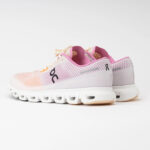 Pair of pastel pink and white running shoes with a chunky segmented white sole or outsole.