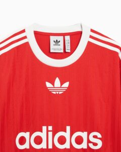 Red Adidas jersey with white collar, white stripes on the sleeves, and the white trefoil logo visible on the chest area.
