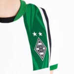 Close-up of a green Borussia Mönchengladbach football jersey sleeve with club crest and two stars.