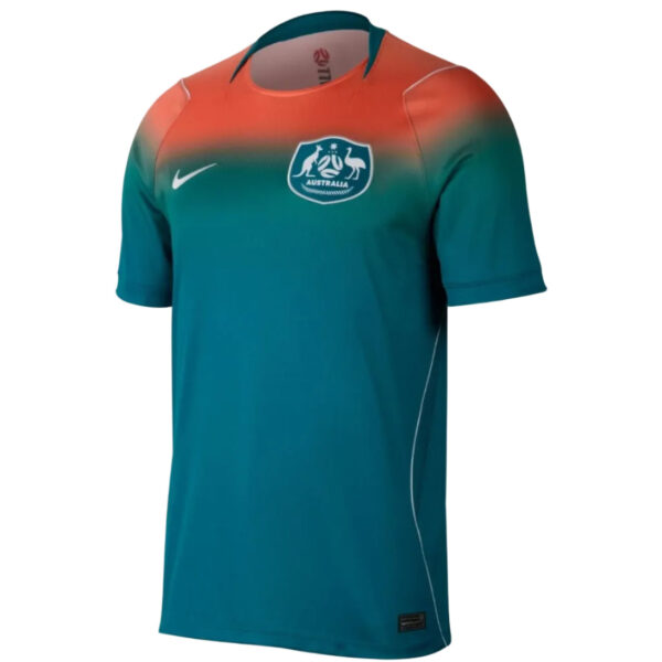 Front view of teal Australia national team soccer jersey with coral gradient across the chest, Nike swoosh, and team crest on the left.