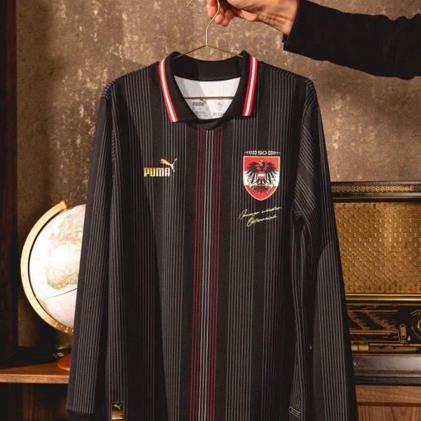 Black pinstriped soccer jersey on a hanger, featuring a red-white striped collar and a crest on the chest.