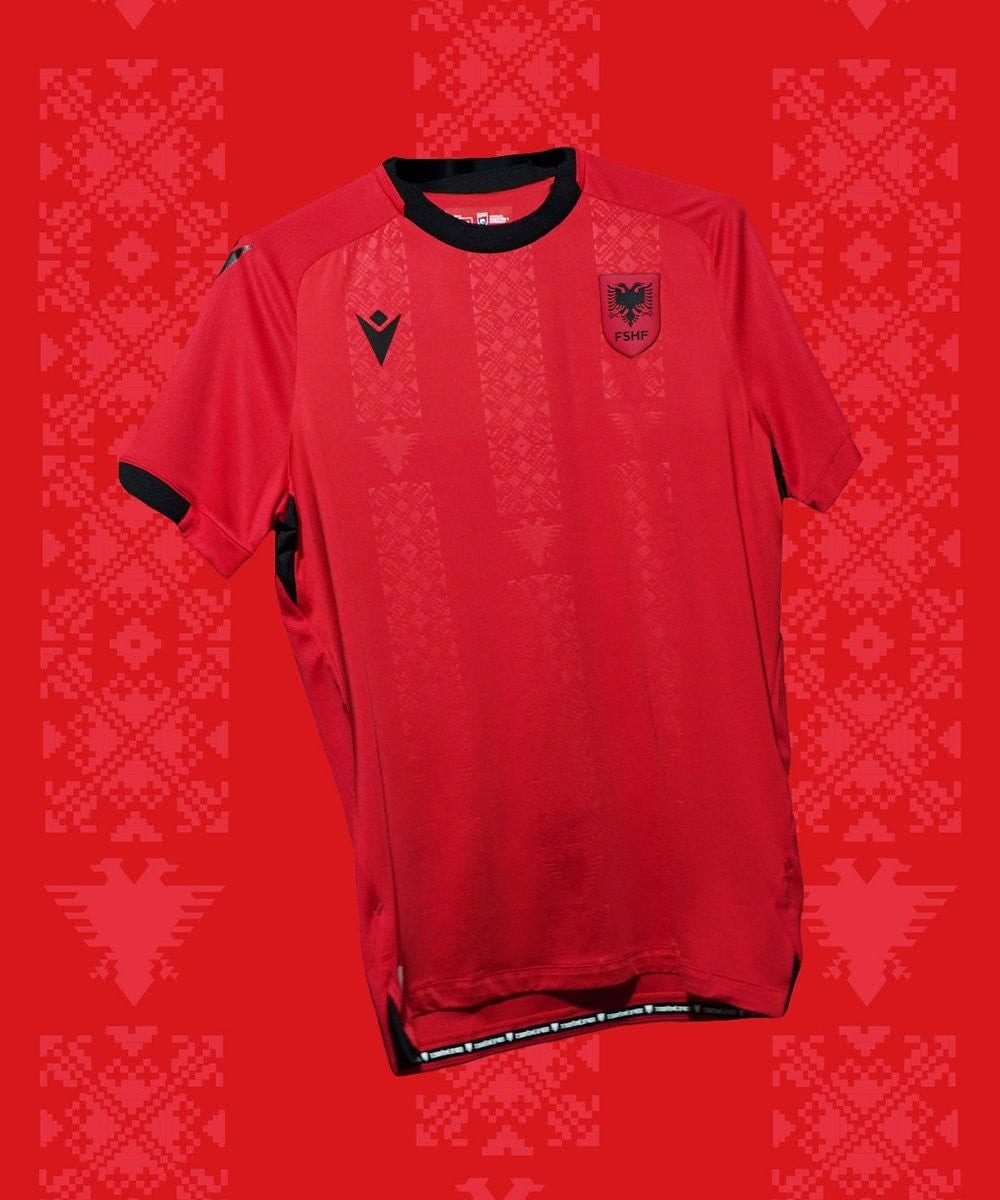 tGNGzKelCJfxE4z | UAE SPORT STORE Red soccer jersey with a black collar and vertical patterned stripes; crest on the left chest and team logo on the right.