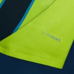 Close-up of neon yellow high-visibility fabric with a dark blue panel and blue stripe, showing the faint 'ULTRALIVE' text along the edge.