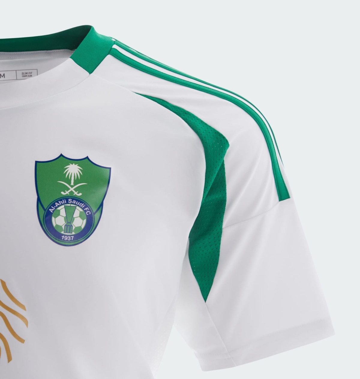 Close-up of a white soccer jersey with green trim and the Al-Ahli Saudi FC crest featuring a palm tree and crossed swords.