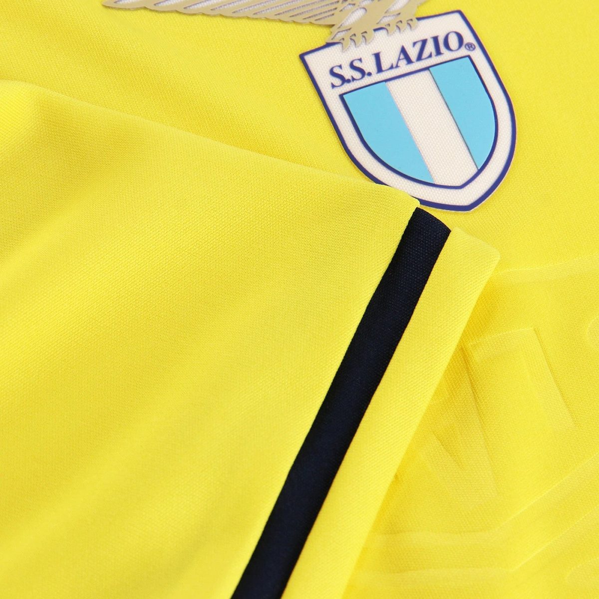 Close-up of a bright yellow Lazio football jersey with the S.S. Lazio crest partially visible on the chest area.