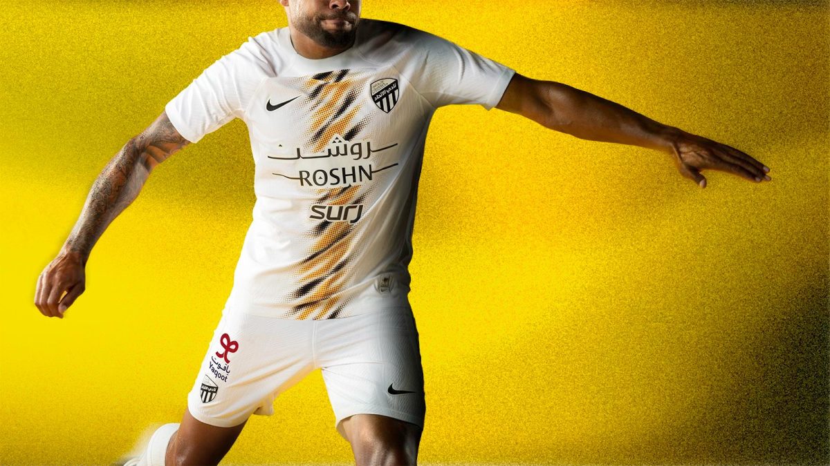 Soccer player in a white kit mid-stride against a bright yellow background.