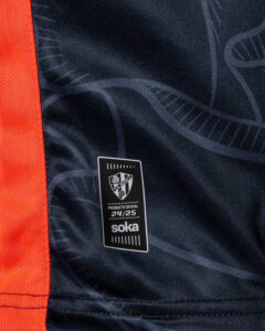 Official product tag on a dark blue jersey showing 24/25 and the brand name 'soka'.