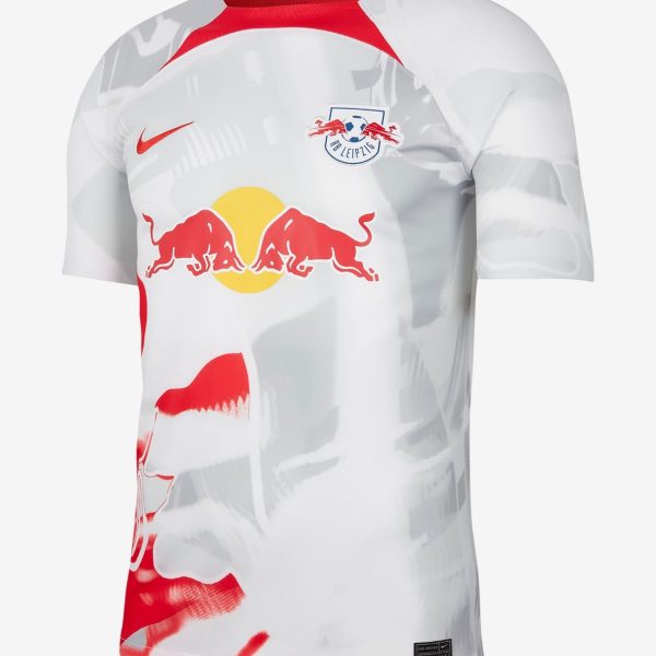 White RB Leipzig football jersey with red collar trim, featuring the Red Bull logo across the chest and the club crest on the left chest.