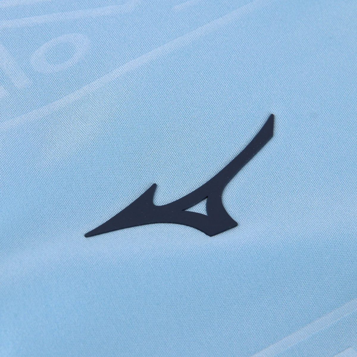 Close-up of a dark blue abstract sports logo on light blue fabric.